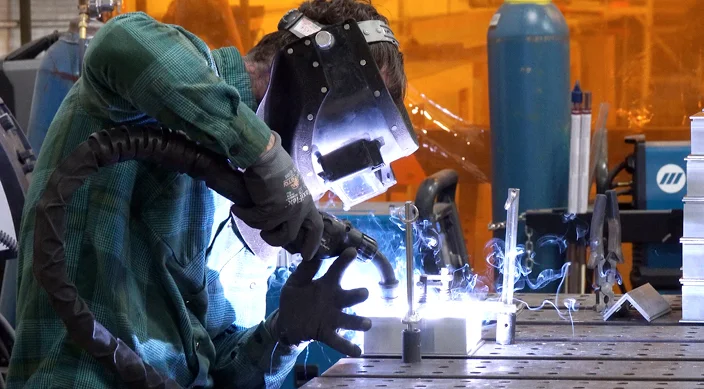 Welder fabricating metal components for Southeastern Architectural Systems